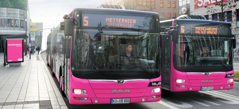 2 nebeneinander fahrende Busse mit Gasantrieb der Koblenzer Verkehrsbetriebe in der Innenstadt vor dem Forum Confluentes