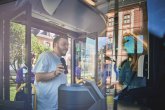 Einsteiger mit Handy Ein junger Mann steigt in den Bus und zeigt dem Fahrer lächelnd sein Handyticket