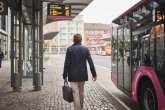 Ein Mann mit Aktentasche hat den Bus verlassen und geht den Bussteig am Hauptbahnhof entlang