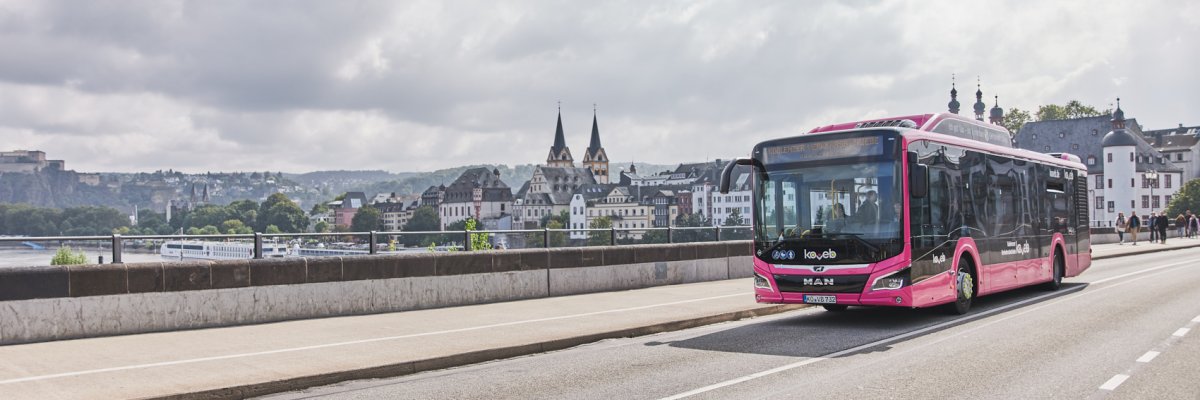 Ein Bus der koveb fährt über die Balduinbrücke - im Hintergrund ist Koblenz zu sehen